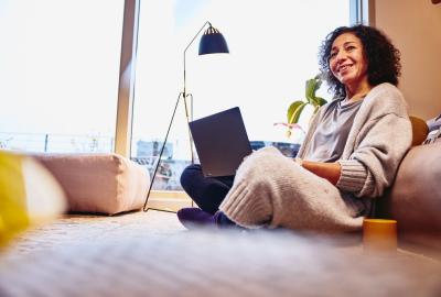 A woman sitting in the living room with her laptop