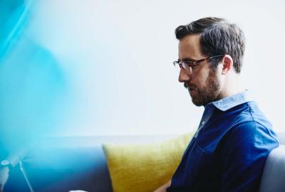 a bearded man wearing glasses reading something