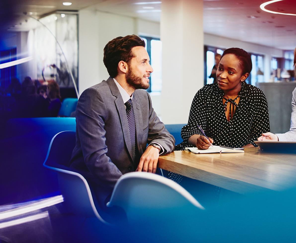 A group of two women and a man talking in the office working in the finance and accounting sector