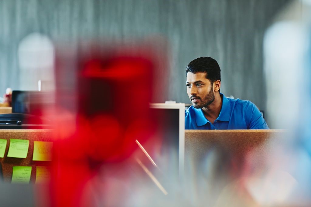 A photo of a  bearded man working in his desk