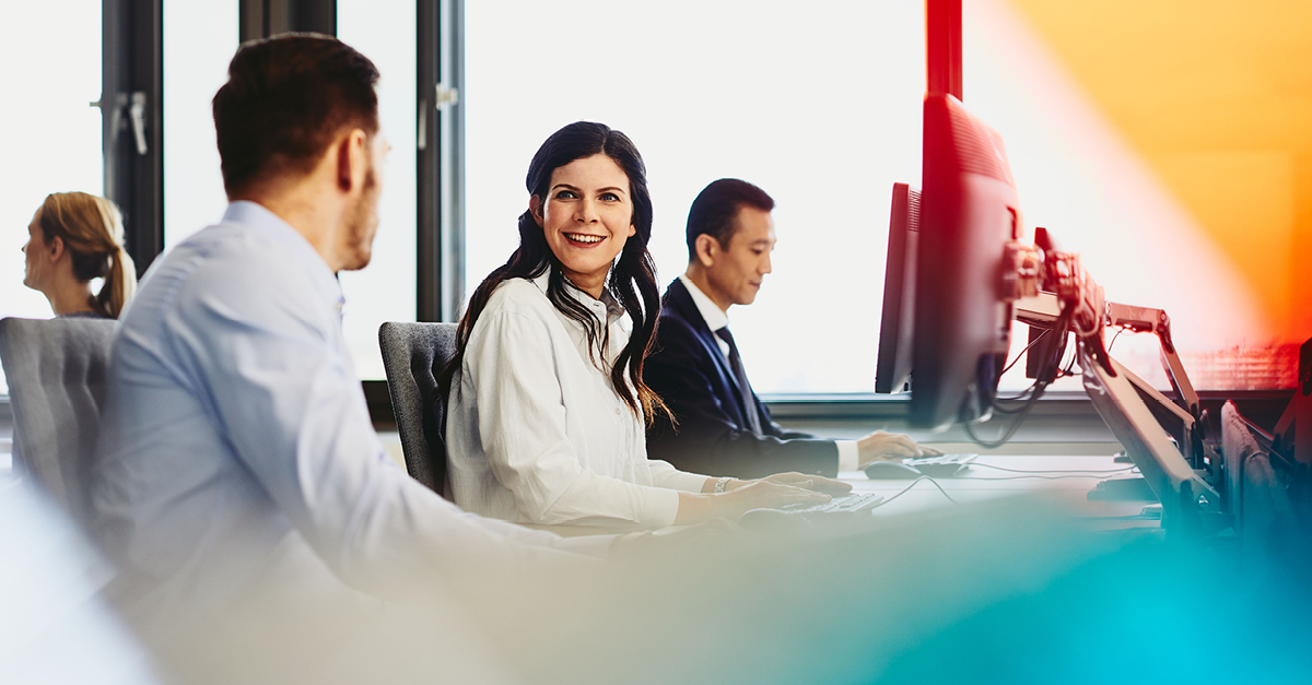 a photo of a woman looking at her coworker while smiling