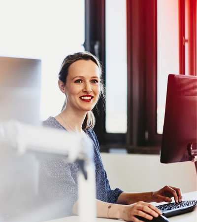 A woman seated in her work area smiling