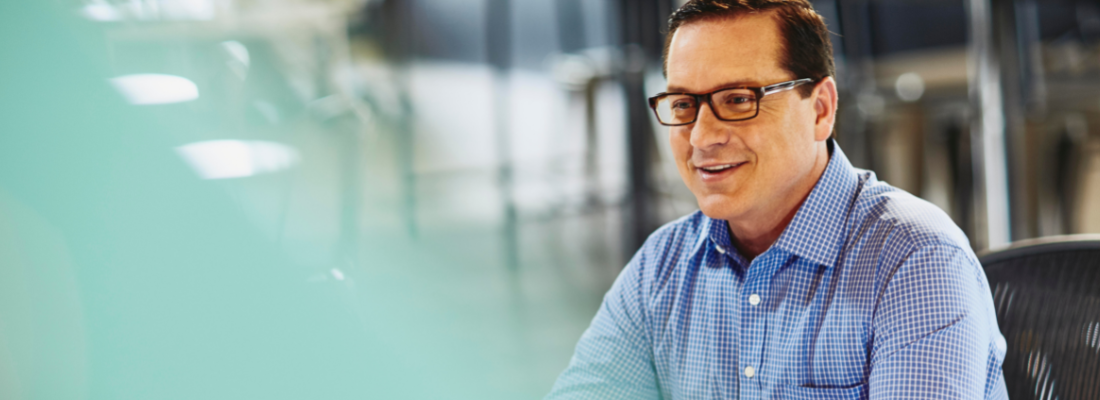 A man wearing glasses smiling 