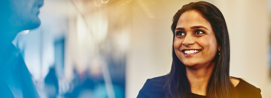A woman smiling at the person she is talking to
