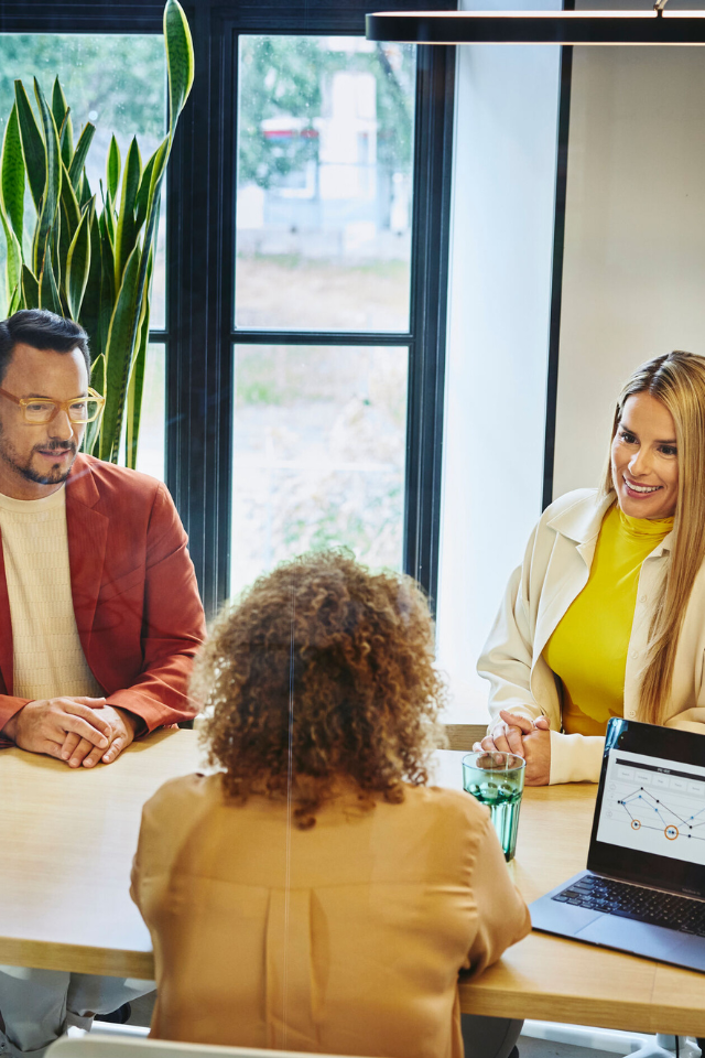 three people talking in a conference room 