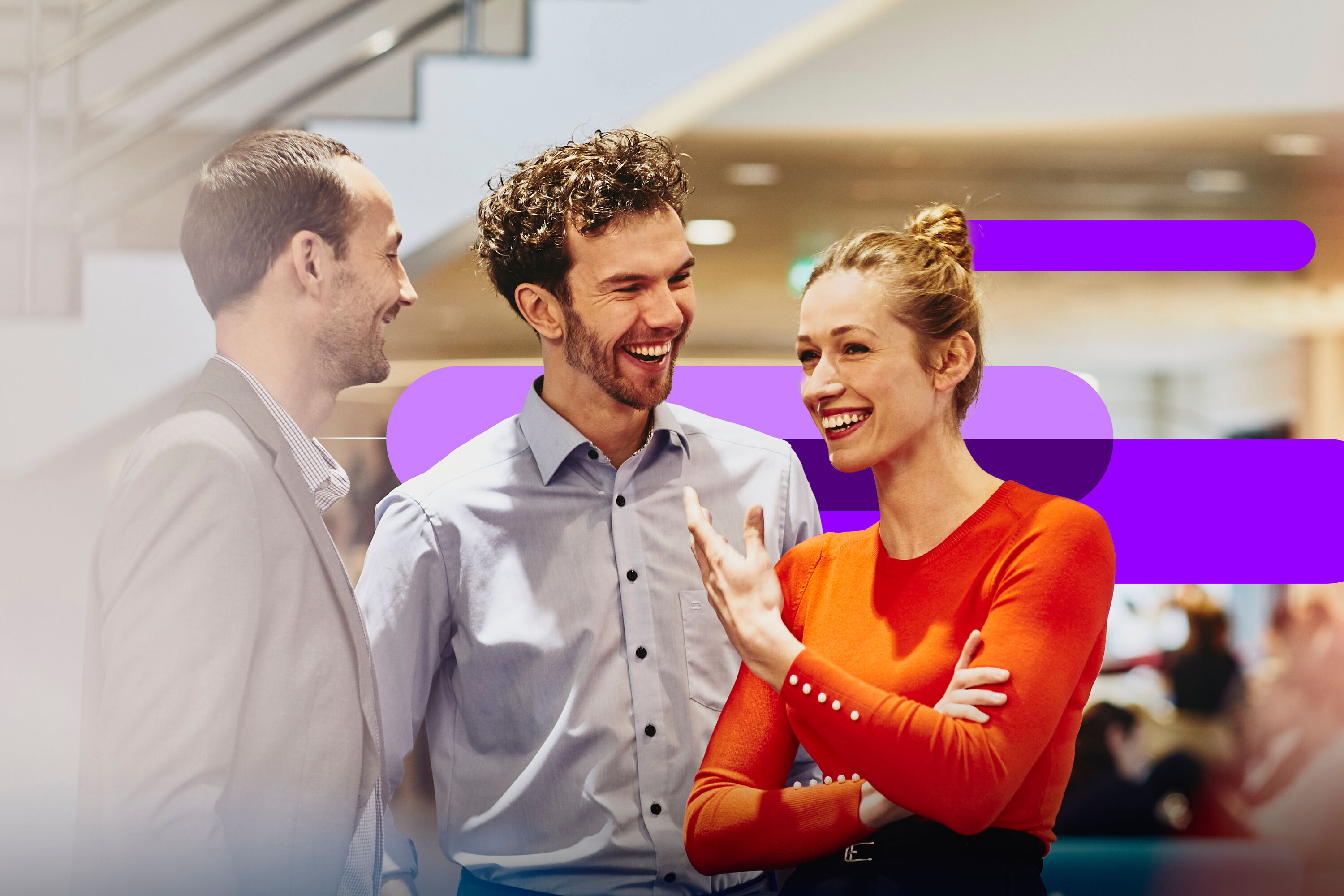 three colleagues having a conversation together in an office setting