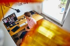 A photo of a man working from home and having a meeting virtually