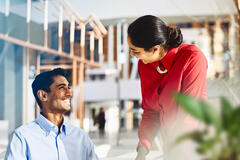 an image of a man smiling brightly at his colleague