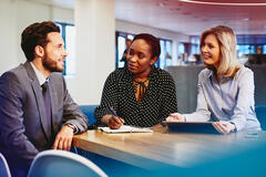 an image of a man wearing a business attire being interviewed by two women