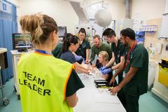 A medical team in a hospital doing a training session. They are being observed by a team leader.