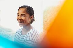 a woman wearing a stripped shirt smiling brightly