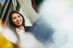 a woman talking to her coworker while smiling 
