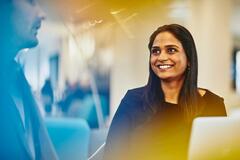 a woman looking at her coworker while smiling brightly