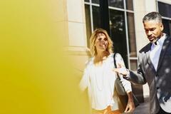 a woman walking with a man smiling and conversing