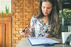 a woman writing something on a piece of paper