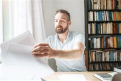 a man working at home and fixing his documents
