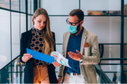 an image of a woman showing her colleague something on a folder 