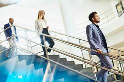 office workers walking down a flight of stairs with an amount of distance