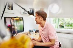 A man working at home and in a virtual meeting