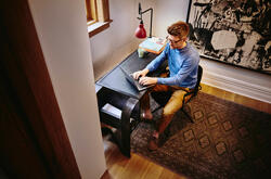 a bird view of a man sitting and working on a laptop