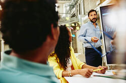 an image of a man presenting data to his colleagues