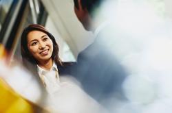 a woman talking to her coworker while smiling 