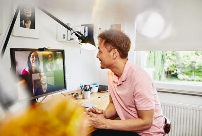 A man working at home and in a virtual meeting