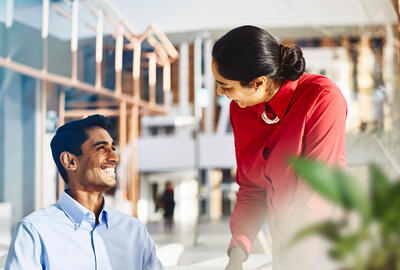 an image of a man smiling brightly at his colleague