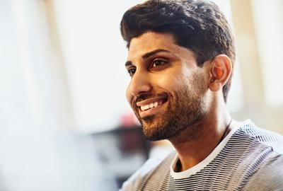 a bearded man looking to the left smiling