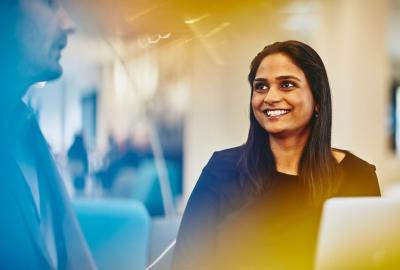 a woman looking at her coworker while smiling brightly