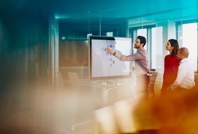 an image of a person presenting something to his team