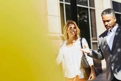 a woman walking with a man smiling and conversing