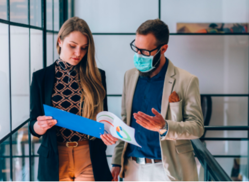 an image of a woman showing her colleague something on a folder 