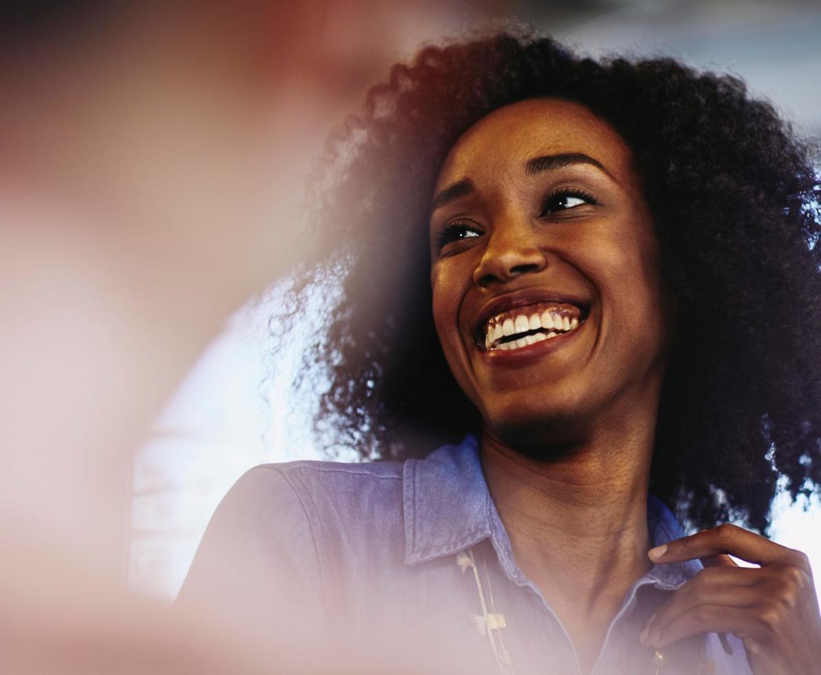 an image of a curly haired woman smiling and wearing a collared shirt