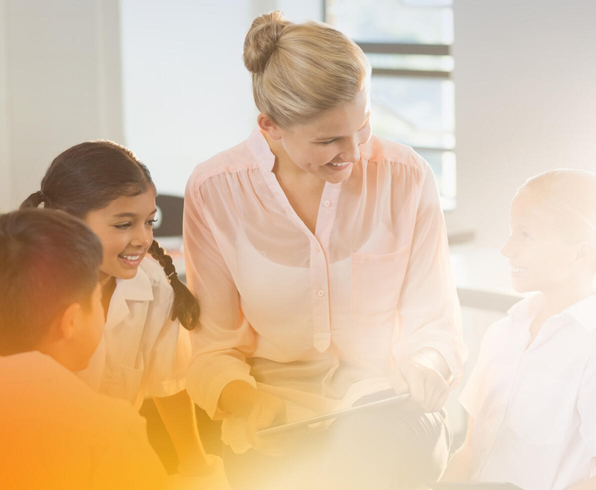 an image of a smiling teacher with students