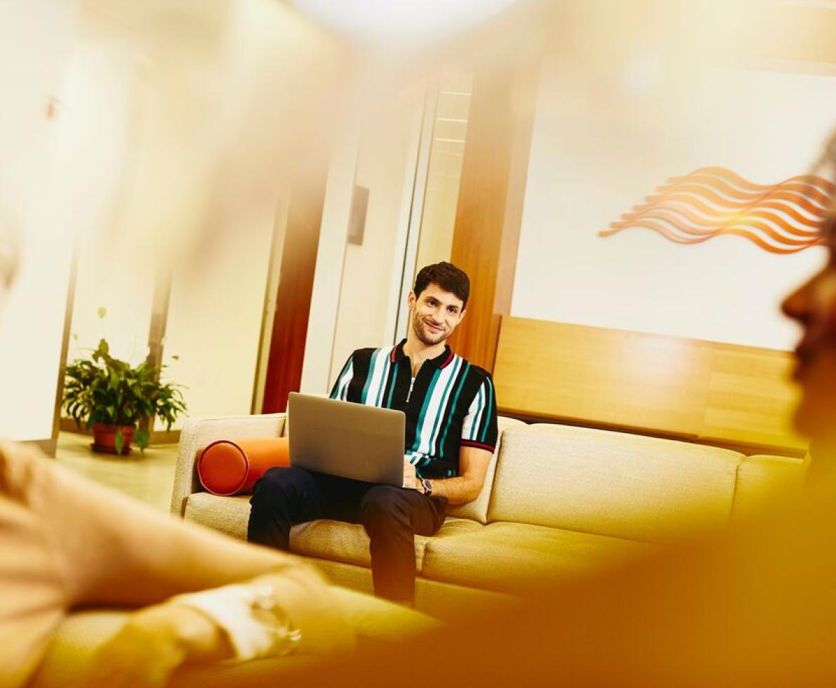 A man sitting in a couch working on his laptop as a developer