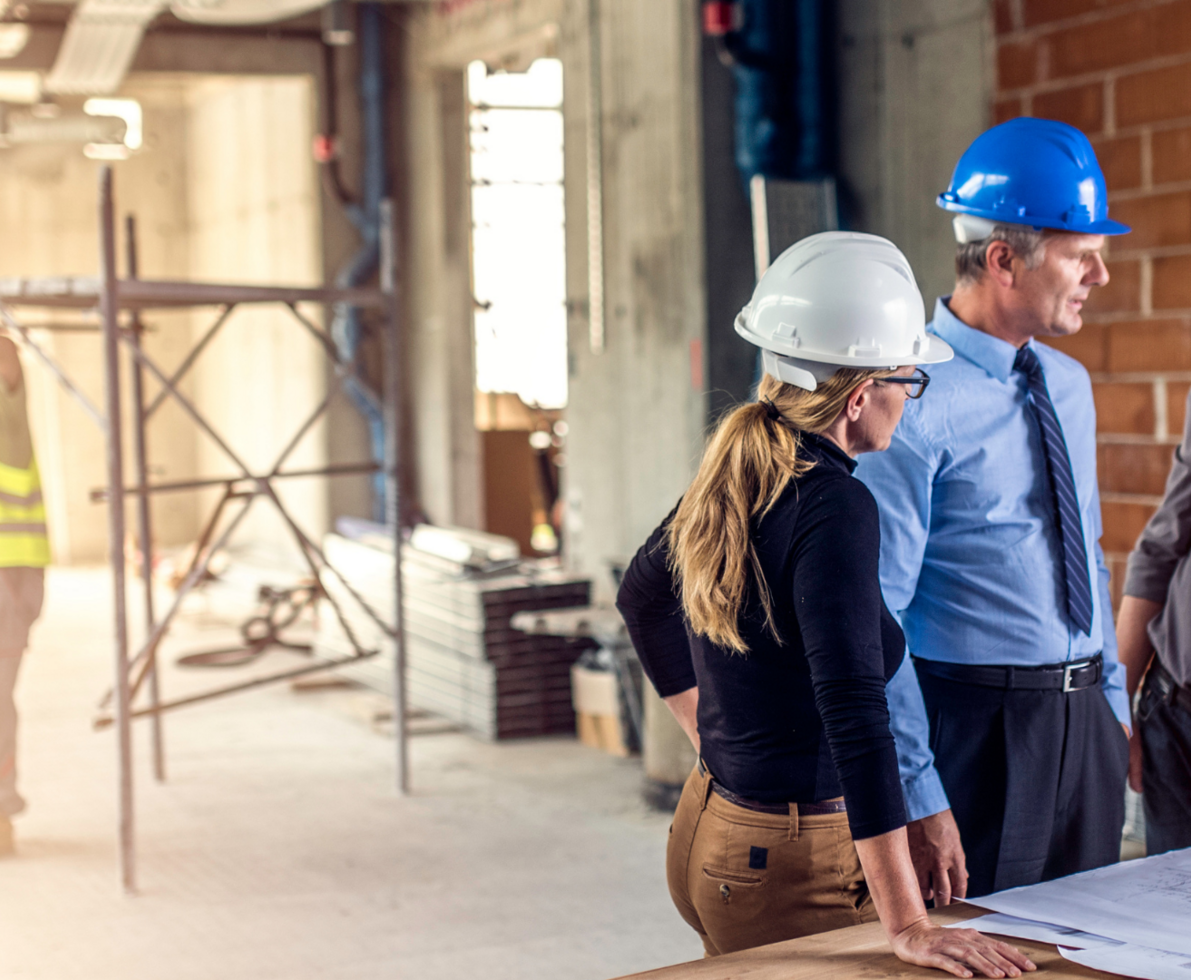 A photo of a woman and two men working in the construction sector