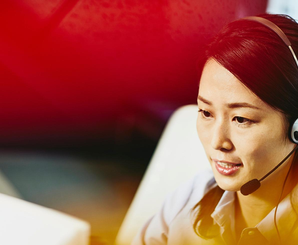 A photo of a woman wearing a headset working in the customer service sector