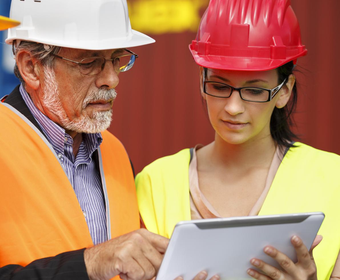 A photo of a middle-aged man and a young woman working in the construction sector