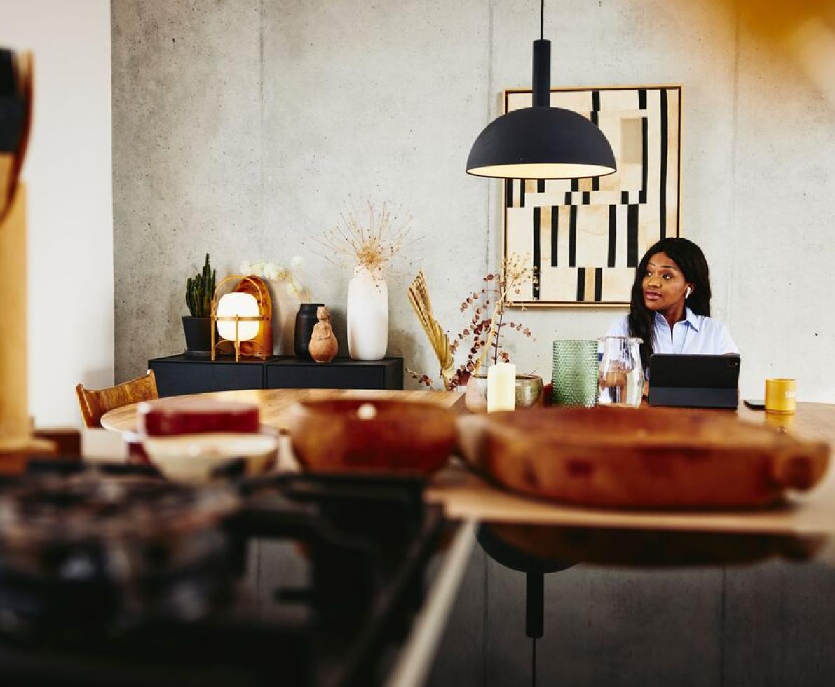 A photo of a woman sitting on a desk designing virtual assessment centres