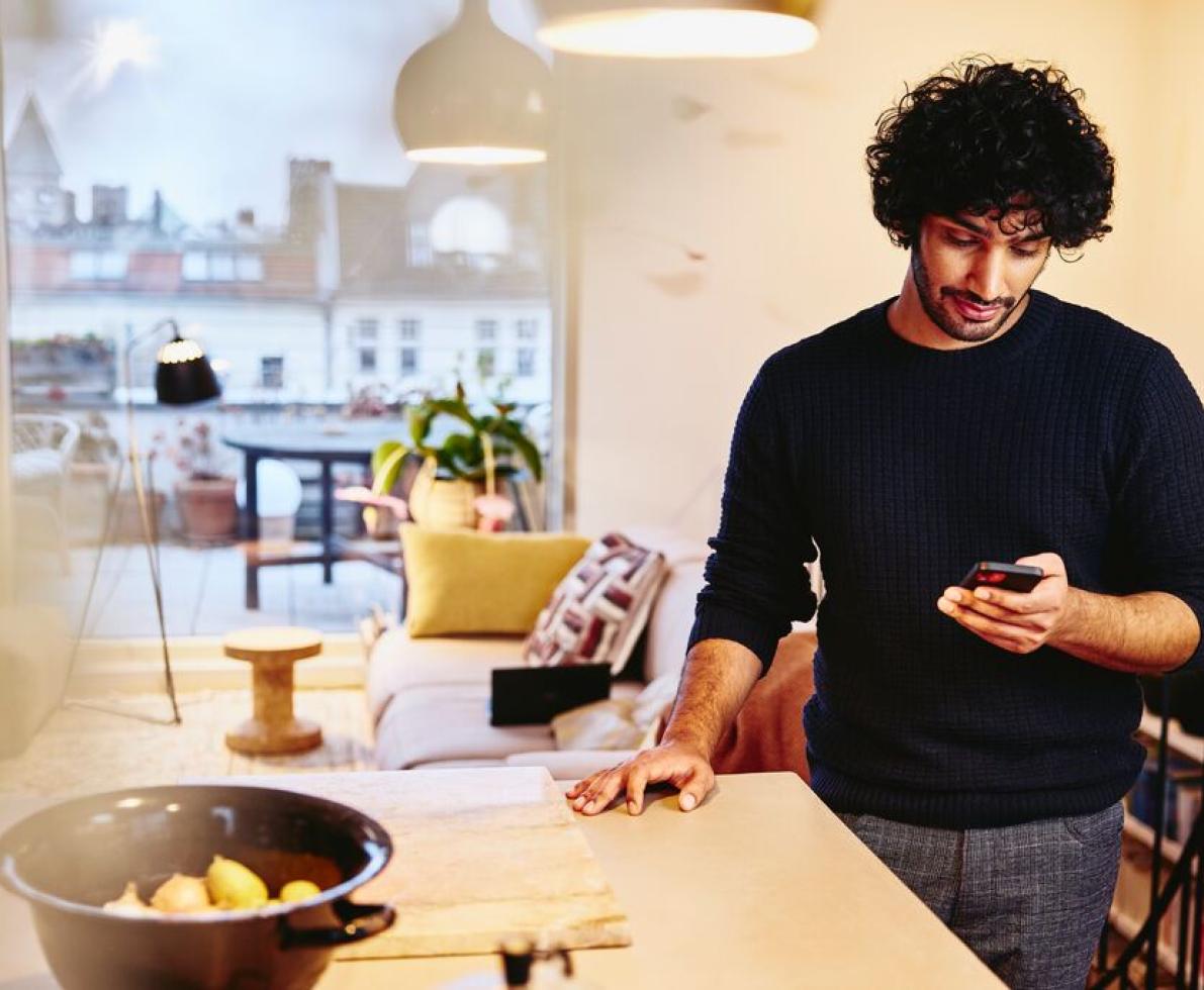 A photo of a man looking at video job ads on his phone