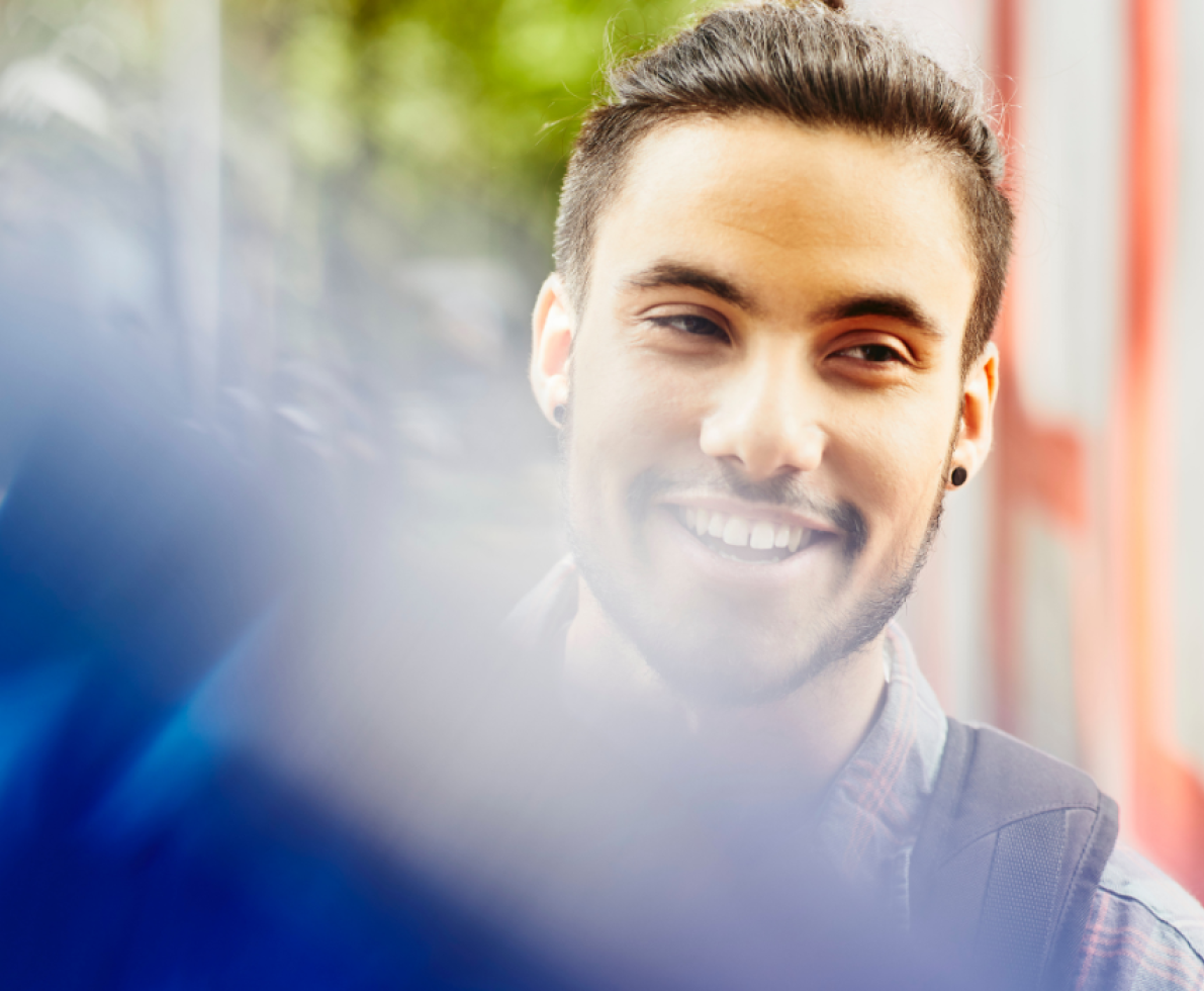 a young man smiling while looking to the far right