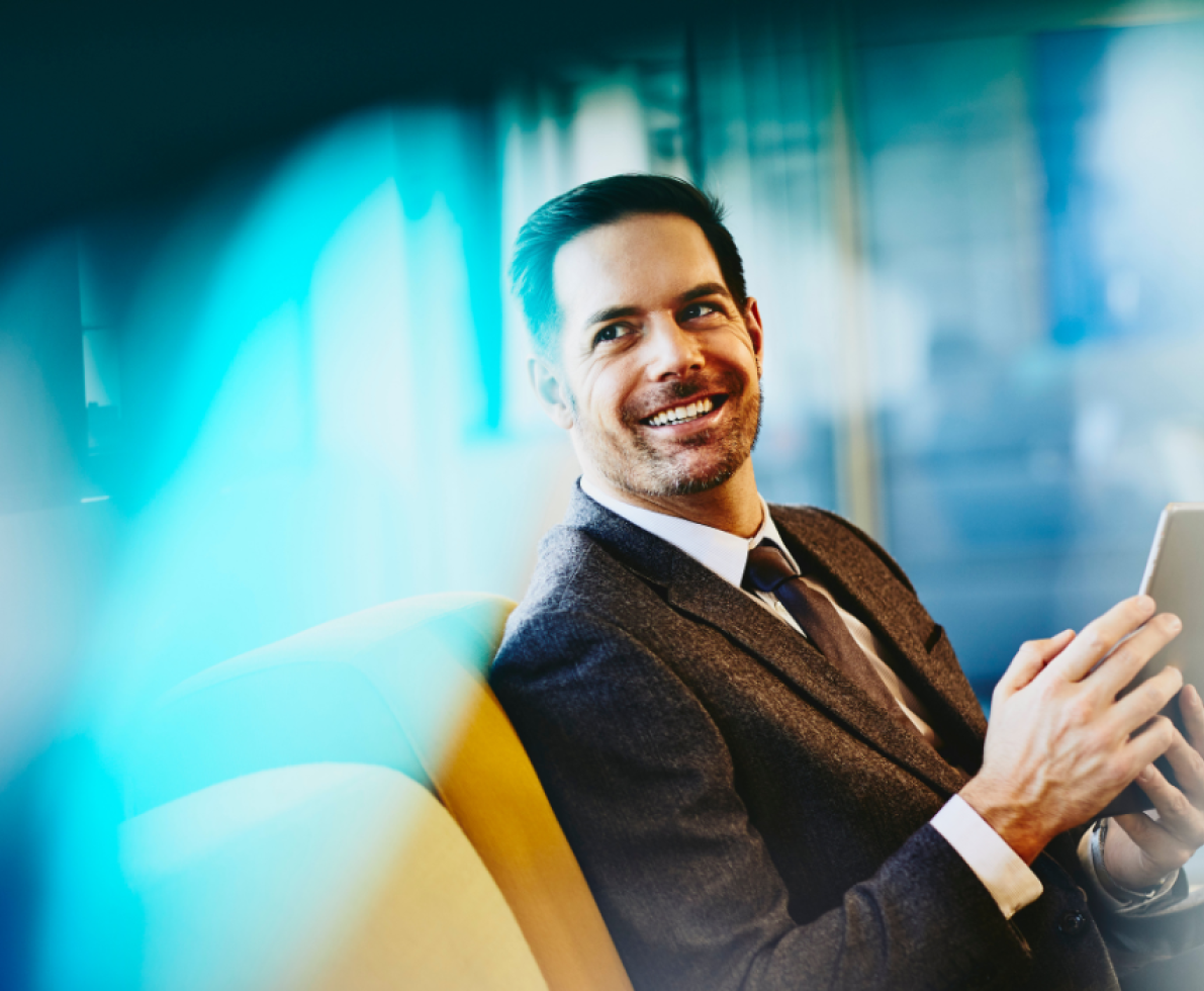 a man holding a tablet while smiling brightly