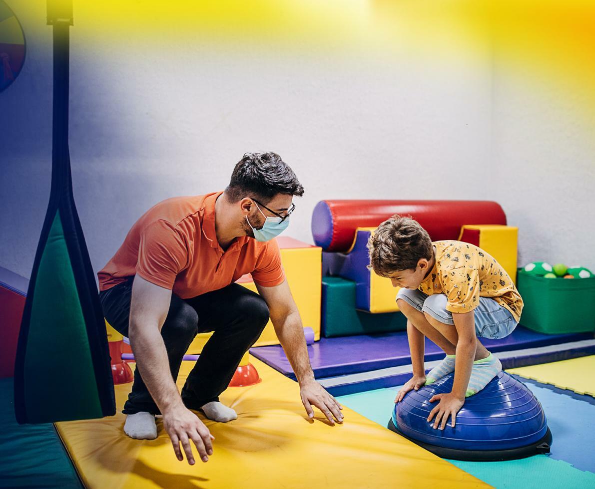 A man teaching a child in a playroom