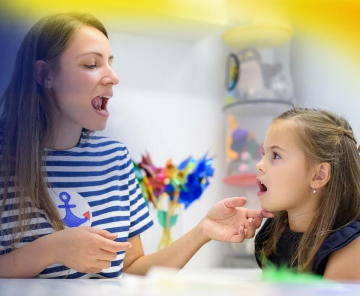 A woman teaching a child how in a playroom