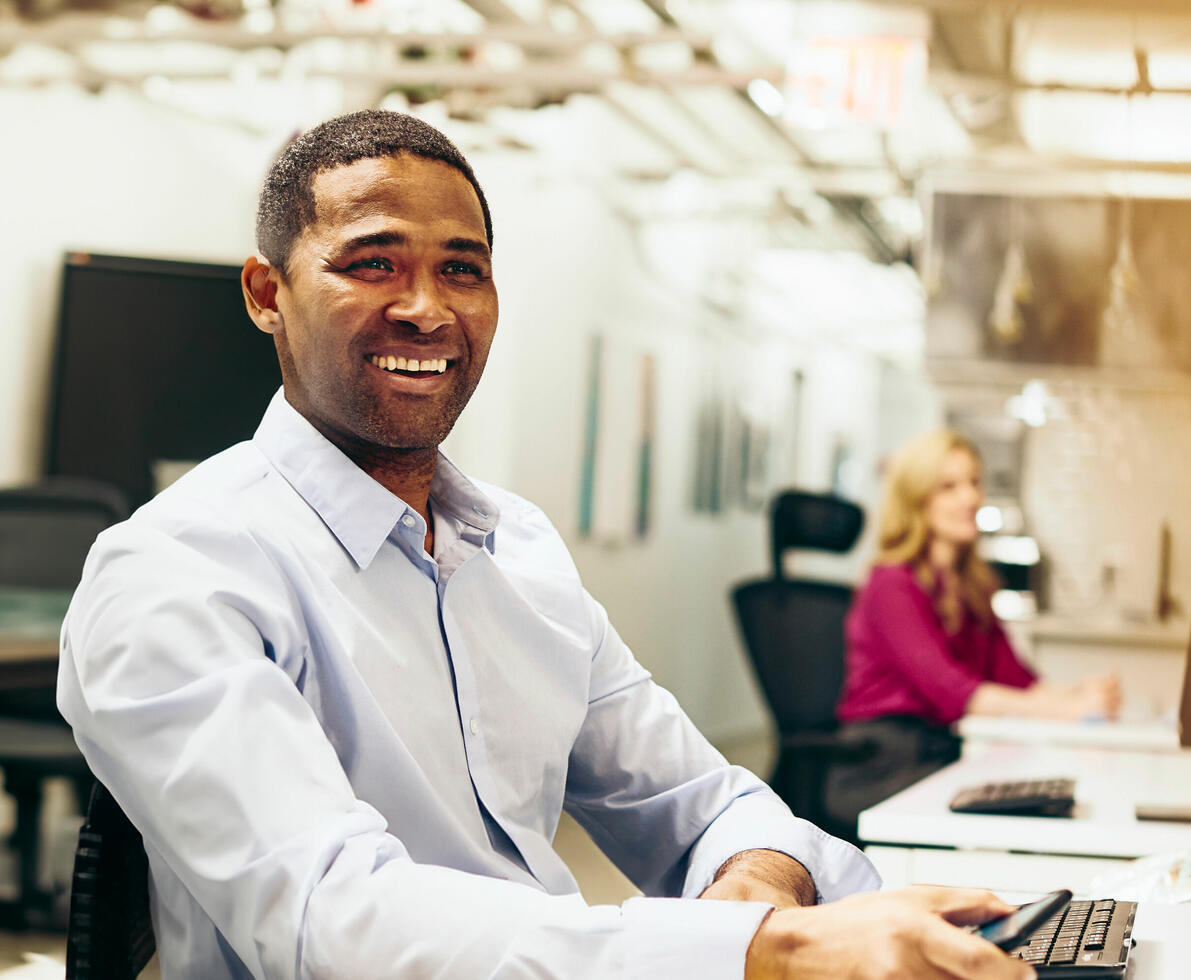 Close up - Smiling male looking away behind a desk