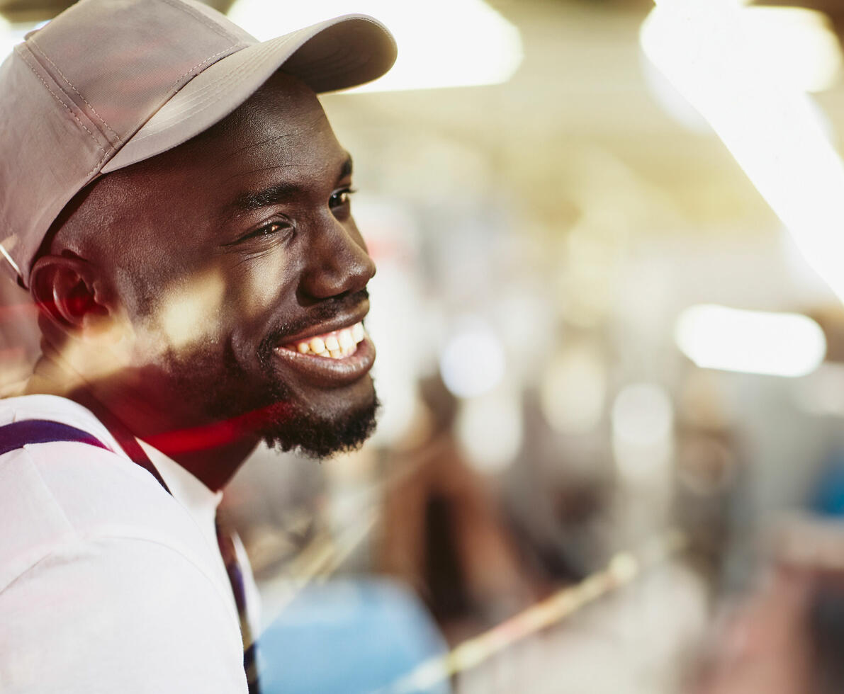 an image of a man wearing a hat smiling while looking to the right