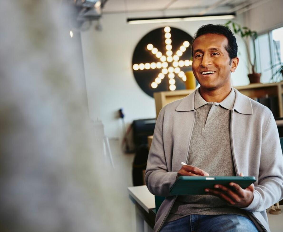 an image of a man interviewing someone while holding his tablet