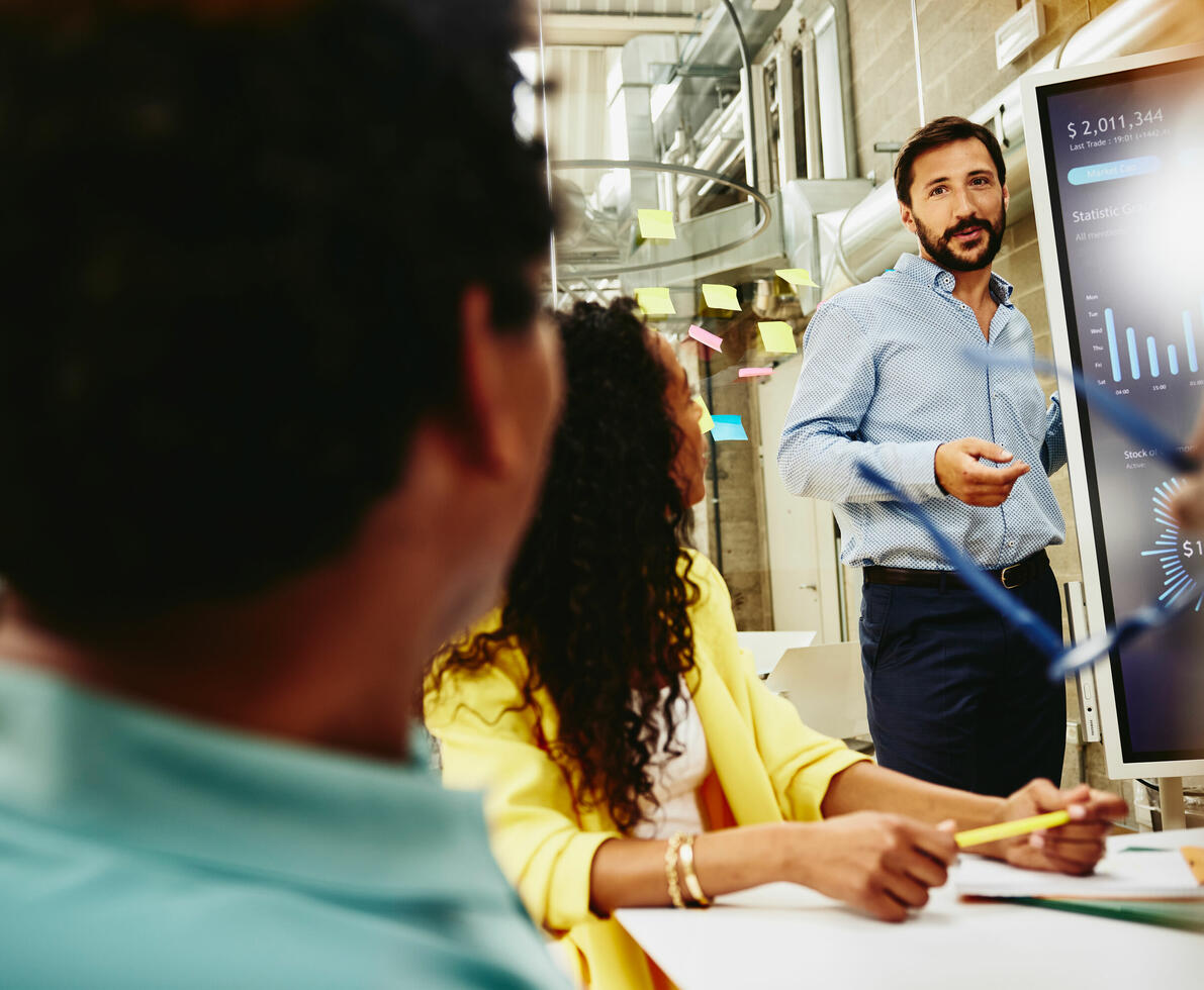 an image of a man presenting data to his colleagues an image of a man presenting data to his colleagues