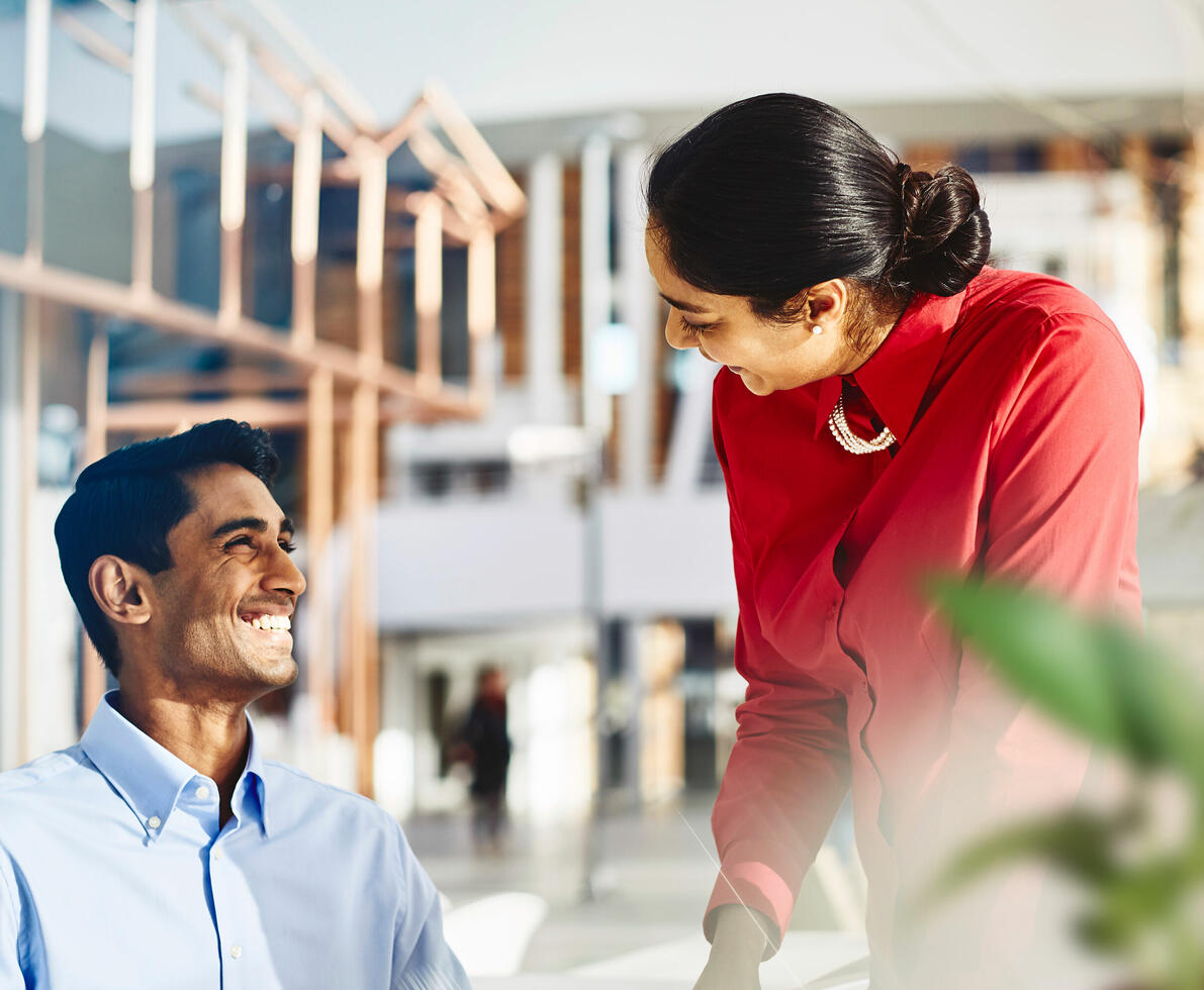 an image of a man smiling brightly at his colleague